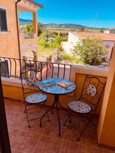 a patio with two chairs and a table on a balcony at perla house in Valledoria