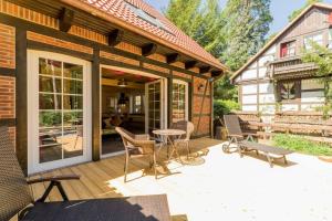 a patio with chairs and a table on a deck at Welsh House in Siedlung Schönwalde