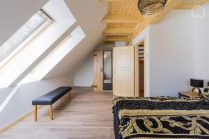 a room with a bed and a bench in a attic at Welsh House in Siedlung Schönwalde +18 photos