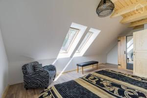 a attic room with a bed and a chair at Welsh House in Siedlung Schönwalde