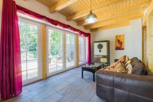 a living room with a couch and large windows at Welsh House in Siedlung Schönwalde