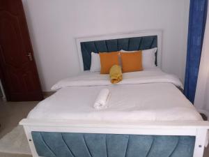 a white bed with a phone on top of it at Nolan's Comforts Kitengela in Kitengela 