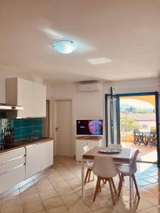 a kitchen and dining room with a table and chairs at perla house in Valledoria