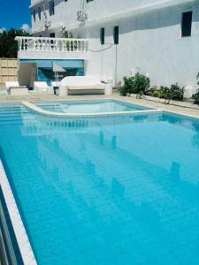 a large swimming pool with blue water in front of a building at Reign homes in Watamu