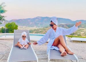 a woman sitting on a chair with a baby in a mirror at Casa Romeriko piscina privada vistas espectaculares Valle de Ricote Murcia in Ricote