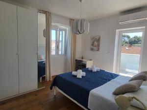 a bedroom with a blue bed with towels on it at Casa Solis Losinj in Mali Lošinj +29 photos