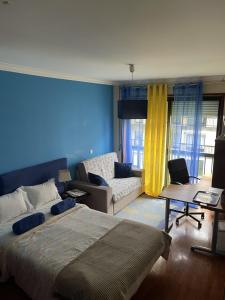 a bedroom with a large bed and a couch at Quarto junto ao mar in Matosinhos