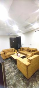 a living room with couches and tables in a room at Dawood Apartments Bahria Town Lahore in Lahore