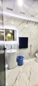 a marble bathroom with a sink and a toilet at Dawood Apartments Bahria Town Lahore in Lahore