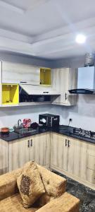 a kitchen with white cabinets and a counter top at Dawood Apartments Bahria Town Lahore in Lahore