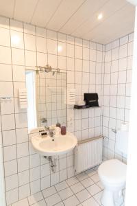 a bathroom with a sink and a toilet at Business Hotel Dernbach in Dernbach +30 photos