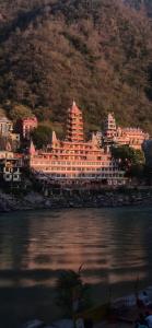 a large hotel on the shore of a body of water at BlaBla House Rishikesh in Rishīkesh