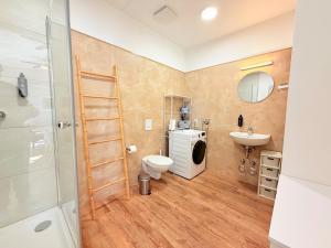 a bathroom with a toilet sink and a washing machine at Amaroo - Serviced Apartments "Branden" in Potsdam
