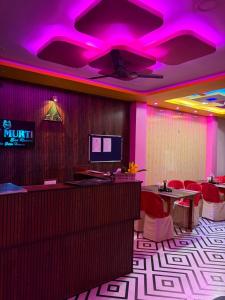 a restaurant with purple lighting and tables and chairs at Dev Murti Eco Resort in Chālsa Mahābāri
