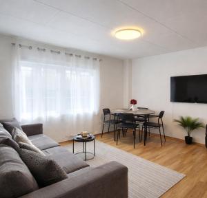 a living room with a couch and a table at Stavanger Sea 1 Ultra Central Dali Apartament General Shop Open 7 l 7 in Stavanger