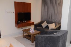 a living room with a couch and a coffee table at شقق نور الفخامه المخدومه in Buraydah +8 photos