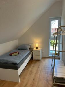 a bedroom with a bed and a ladder and a window at Seebrise in Geeste
