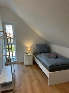 a bedroom with a bed and a ladder and a window at Seebrise in Geeste +14 photos
