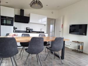 a dining room with a wooden table and chairs at Torenvalk 32 in Hulshorst