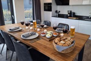 a wooden table with glasses of wine and a basket of bread at Torenvalk 32 in Hulshorst +6 photos