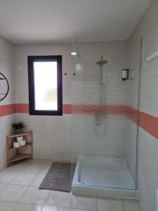 a bathroom with a shower with a tub and a window at Sunhouse in Playa Honda
