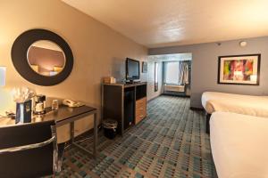 a hotel room with two beds and a desk and a mirror at Studio 6 Amarillo, TX West Medical Center in Amarillo