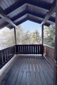 a porch of a wooden deck with trees in the background at Nalas Auszeit in Regen