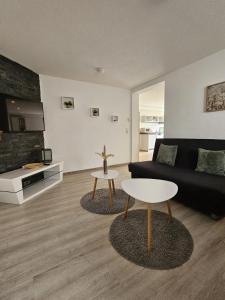 a living room with a black couch and a table at Ferienwohnung Alina in Rust
