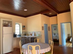 a kitchen with a table with chairs and a refrigerator at Casa Terra in Rio Maior