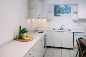a white kitchen with a bowl of fruit on the counter at Yviome Rhodes Central Escape in Rhodes Town