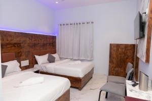 a hotel room with two beds and a chair at Hotel Midnight Lodging & Boarding in Panvel