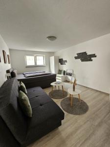 a living room with a black couch and tables at Ferienwohnung Alina in Rust