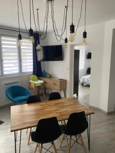 a dining room with a wooden table and chairs at Logement Poséidon in Boulogne-sur-Mer
