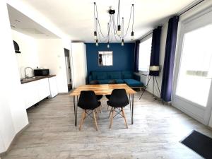 a dining room with a wooden table and black chairs at Logement Poséidon in Boulogne-sur-Mer +4 photos