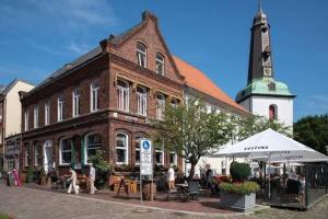 a large brick building with people sitting outside of it at Stilbruch Glückstadt in Glückstadt