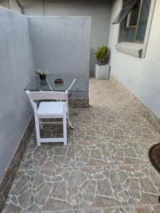 a patio with a table and a chair on a stone floor at Cjabaledi Guesthouse in Centurion