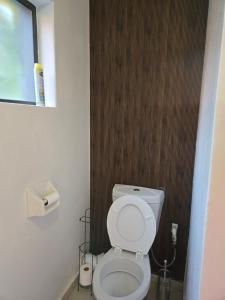 a bathroom with a white toilet and a brown wall at Cjabaledi Guesthouse in Centurion