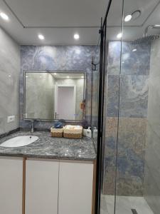 a bathroom with a sink and a glass shower at Paris and Eneas Studios in Vlorë +39 photos