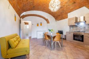 a living room with a yellow couch and a table at Windrose Cottage di Gio in Pisa