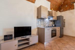 a kitchen with a tv on a stand with a tv at Windrose Cottage di Gio in Pisa +18 photos