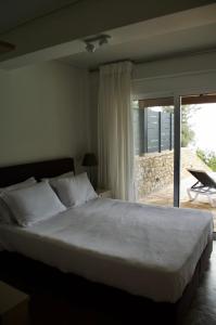 a bedroom with a large bed and a sliding glass door at Apollo Romantic Sea View Villa in Kiveri +41 photos