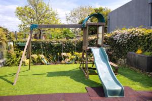 a playground with a slide in a garden at Herama Garden Guesthouse in Vila Nova de Gaia