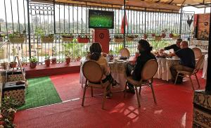a group of people sitting at tables in a restaurant at Riad Imperial Atlas in Meknès