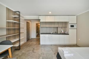 a kitchen with white cabinets and a table in a room at Sea lounge in Varna City