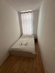 a small bedroom with a bed with two shoes on it at Cozy Ground Floor Apartment Near U6 Easy Access to Center in Vienna