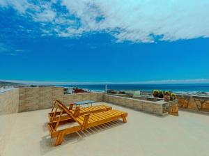 two wooden benches sitting on top of a roof at Berber Surf House in Tamraght Ouzdar