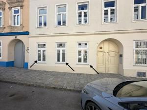 a building with four doors and a car parked in front at Cozy Ground Floor Apartment Near U6 Easy Access to Center in Vienna