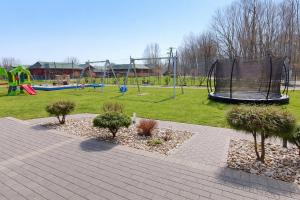 a park with a playground with a trampoline at Umberto Apartamenty Dwupoziomowe Dąbki in Dąbki