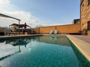 a swimming pool with blue water in front of a building at Wellness Casa Doña Juana in Tepoztlán +5 photos