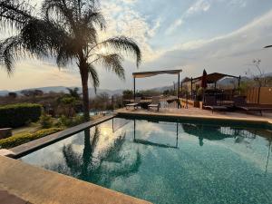 a swimming pool with chairs and a palm tree at Wellness Casa Doña Juana in Tepoztlán